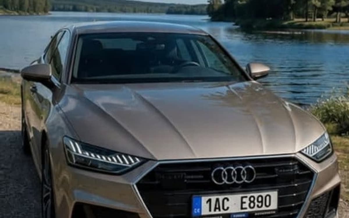 Audi A7 Sportback ve stříbrné barvě zepředu u přehrady